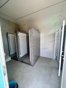 a bathroom with three doors in a room at Recanto dos Loureiros - Serrinha do Mendanha in Marapicu