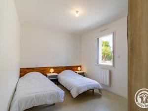 deux lits dans une chambre avec une fenêtre dans l'établissement Gîte moderne avec jardin clos et animaux admis près de Nantes et Angers - FR-1-622-108, à Saint-Christophe-la-Couperie