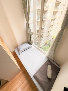 a small bed in a room with a large window at Oslandmark Residence in Bandung +16 photos