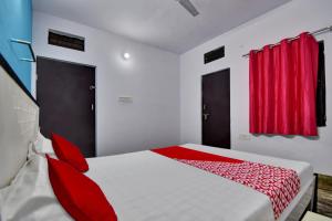 a bedroom with a large bed with red accents at Hotel O HM & Restaurant in Begās