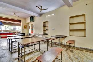 a classroom with tables and benches in a room at Hotel O HM & Restaurant in Begās