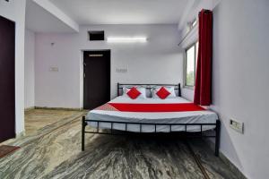 a bedroom with a bed with red pillows on it at Hotel O HM & Restaurant in Begās
