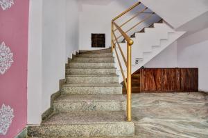 a staircase with a metal handrail and a stair case at Hotel O HM & Restaurant in Begās