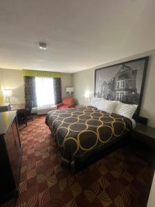 a hotel room with a large bed and a window at Super 8 by Wyndham Lake of the Ozarks in Eldon +19 photos
