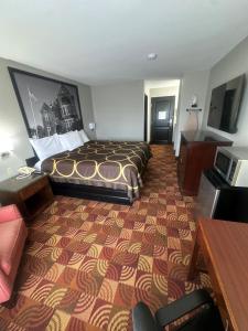 a large hotel room with a bed and a desk at Super 8 by Wyndham Lake of the Ozarks in Eldon