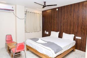 a bedroom with a bed and a red chair at Rama grand in Tirupati