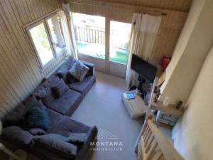 un salon avec un canapé et une télévision dans l'établissement Charmant 4 pièces + mezzanine pour 8 personnes au Grand-Bornand - FR-1-458-220, au Grand-Bornand
