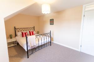 a bedroom with a bed with red pillows at Spacious 4-Bedroom home - Garden & Parking - Dunoon in Dunoon