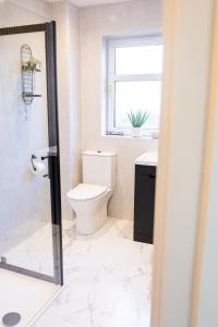 a bathroom with a toilet and a sink and a window at Spacious 4-Bedroom home - Garden & Parking - Dunoon in Dunoon