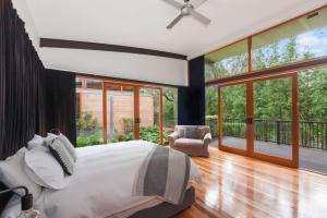 a bedroom with a bed and a balcony with sliding glass doors at Elements - Echuca Holiday Homes in Moama