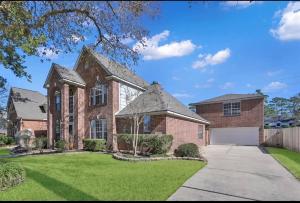a large brick house with a white garage at Luxurious Tomball Getaway in Tomball