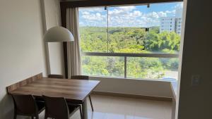 a dining room with a table and a large window at PARK VEREDAS - Apto 415 - Vista para Piscina in Rio Quente