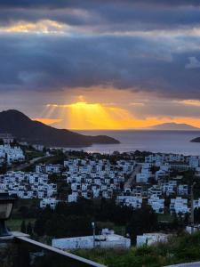a view of a city with the sunset in the background at Seaside villa Sunrise Sea view, fully Private Pool in Akyarlar