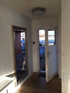 a room with a mirror and a door with a balcony at Ferienwohnung "Seglersteg, Bungalow 11" Hafenspitze in Eckernförde