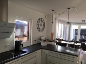 a kitchen with a large clock on the wall at Ferienwohnung "Seglersteg, Bungalow 11" Hafenspitze in Eckernförde