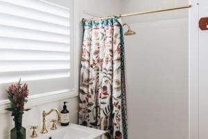 una tenda per la doccia in un bagno con lavandino di Coromandel Cottage, Berrima a Berrima 1 altra foto