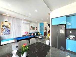 a dining room with a blue table and chairs at NOVA WORLD PHAN THIẾT - An VILLA in Bình Tú