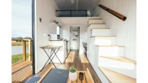 a tiny house with a staircase and a kitchen at Little Lady Cabin by Tiny Away in Rylstone