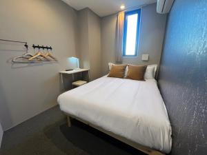 a bedroom with a white bed with a window at Hostel Hangout Best Value Near Kuromon Market & Namba in Osaka