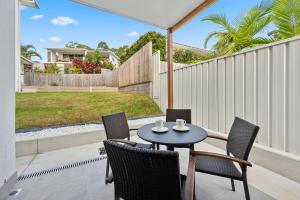 Un patio con mesa y sillas y una valla. en The Break on Diggers - Popular Location, walk to Beach, en Coffs Harbour
