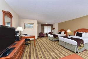 a hotel room with two beds and a flat screen tv at AmericInn by Wyndham La Crosse Riverfront-Conference Center in Onalaska