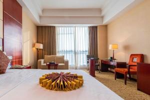 青岛Qingdao Chengyang Detai Hotel的一间带大床和客厅的酒店房间 更多166张照片