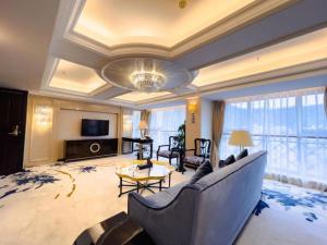 a large living room with a couch and a television at Yunhai Hotel Zhuhai in Zhuhai