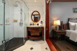 un bagno con doccia, lavandino e specchio di La Sinfonía Majesty Hotel and Spa a Hanoi