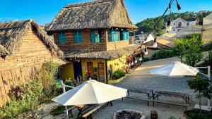 ダラットにあるMái Lá Homestay & Herbal Spaの建物前の白傘2本