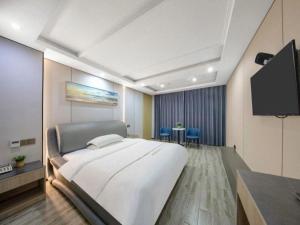a hospital room with a bed and a flat screen tv at GreenTree Alliance Ningbo Cixi Guanghaiwei Industrial Park East Area Hotel in Ningbo
