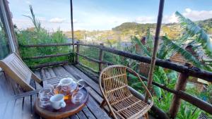 Mái Lá Homestay & Herbal Spa في دالات: طاولة وكراسي على سطح خشبي مع اطلالة