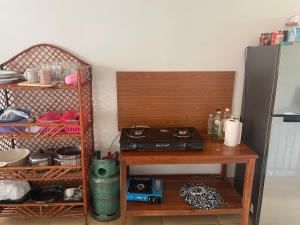 a kitchen with a wooden table and a refrigerator at Zeus Hotel in Siem Reap