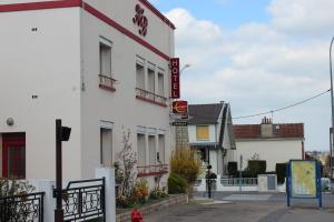 a white building with a sign on the side of it at Hotel Bristol in Châlons-en-Champagne