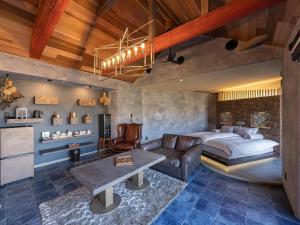 a bedroom with a bed and a couch and a table at Yufuin Luxury Villa -zakuro- in Yufuin +164 photos