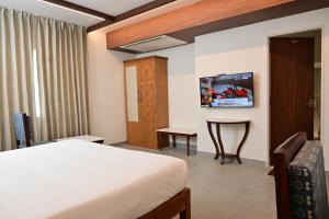 a hotel room with a bed and a table at Rathna Residency in Tiruppattūr