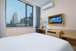 a hotel room with a bed and a large window at City Comfort Inn Wuhan Zhongnan Road Fujiaopo in Wuhan