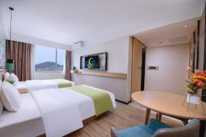 a hotel room with two beds and a table at City Comfort Inn Nanning Yudong Jinxiang Metro Station in Nanning +247 photos