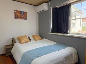 a bed in a bedroom with a window at NewDayHouse日式洋房独栋最多住10人 新今宫站近温泉通天阁天王寺 机场直达 半小时到世博会 in Osaka