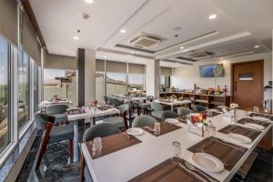 a restaurant with tables and chairs and windows at Lords Eco Inn Jawai- Sumerpur in Sheoganj