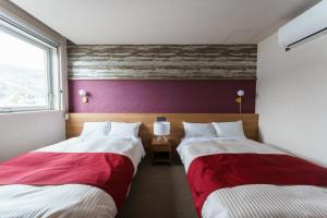 2 posti letto in camera d'albergo con rosso e bianco di グリーンサンホテル a Shimo-suwa