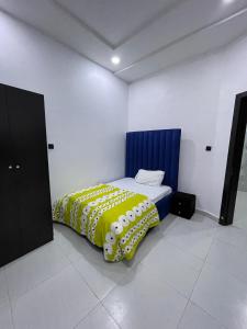 a bed with a yellow blanket in a room at A Cozy 4 Bedrooms Terrace Home Located in Orchid Road in Lekki