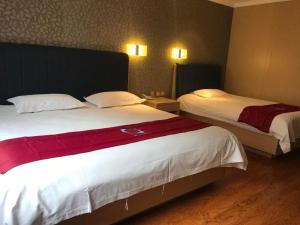 a hotel room with two beds with red sheets at PAI Hotels Jinzhou Yi County Railway Station in Jinzhou