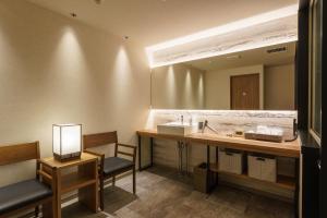 un bagno con lavandino e specchio di グリーンサンホテル a Shimo-suwa