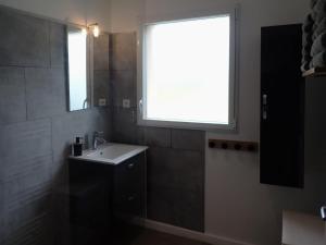 a bathroom with a sink and a window at maison de vacances locquirec in Locquirec