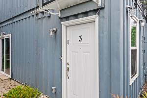 a blue building with a white door with the number three at Experience the Unique Re-Nu Shipping Container #3 in Louisville