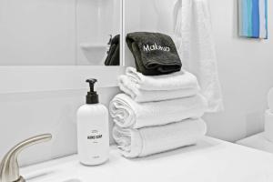 a stack of towels on a bathroom counter with a bottle of soap at Experience the Unique Re-Nu Shipping Container #3 in Louisville