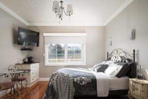 una camera da letto con un letto, una TV e una finestra di Noah's Stanley Luxury Bed and Breakfast a Stanley