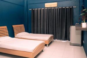 two beds in a room with blue walls at The Mansion Pakchong in Mu Si
