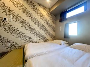 two beds in a room with a wall covered in animal prints at Hostel Hangout Best Value Near Kuromon Market & Namba in Osaka