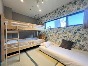 a bedroom with two bunk beds and a window at Hostel Hangout Best Value Near Kuromon Market & Namba in Osaka +90 photos